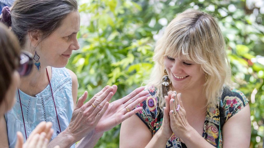 Two women smiling and slapping together